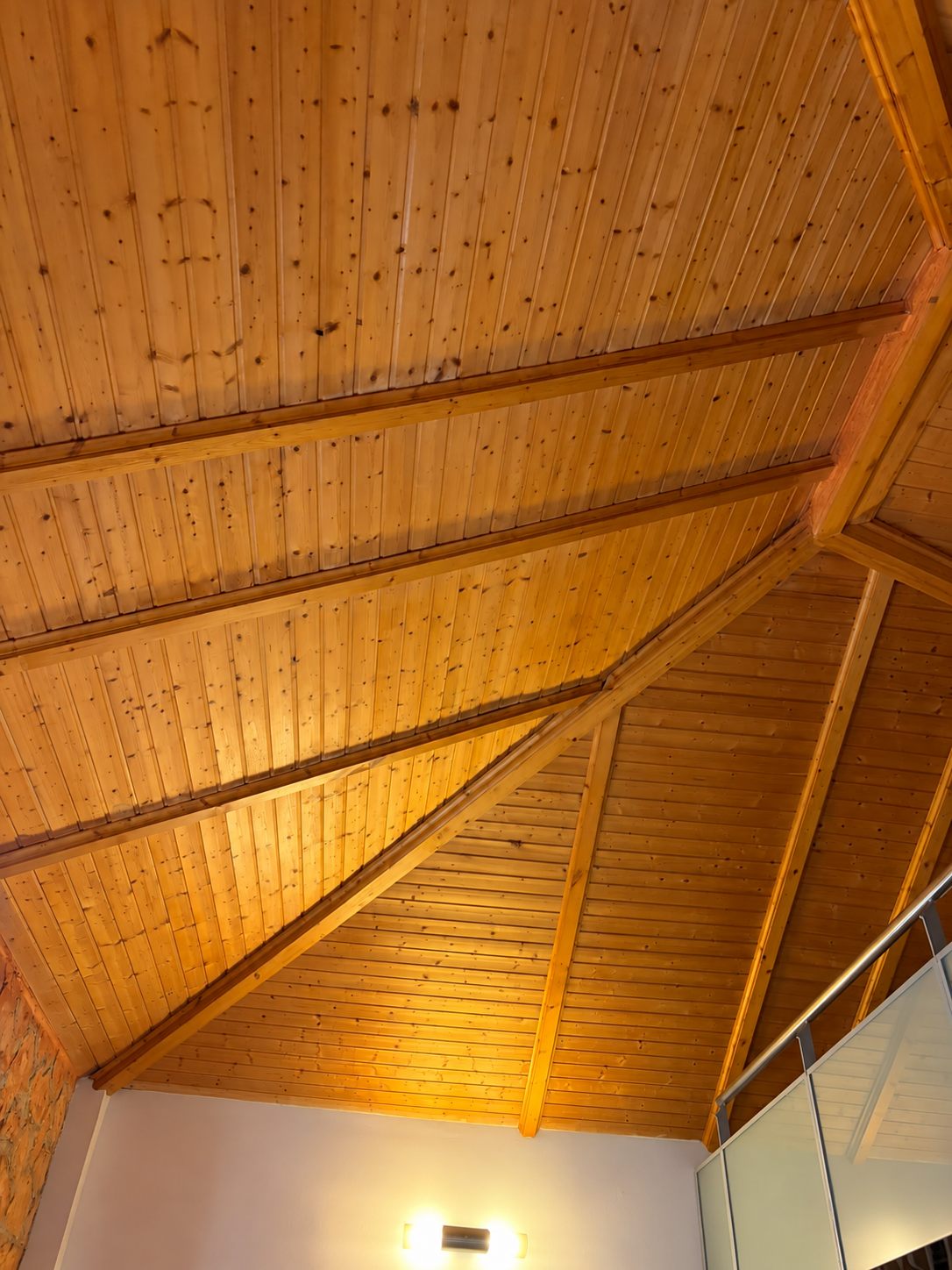 Revestimiento interior de cubierta de madera con vigas y distintos planos en La Cañada