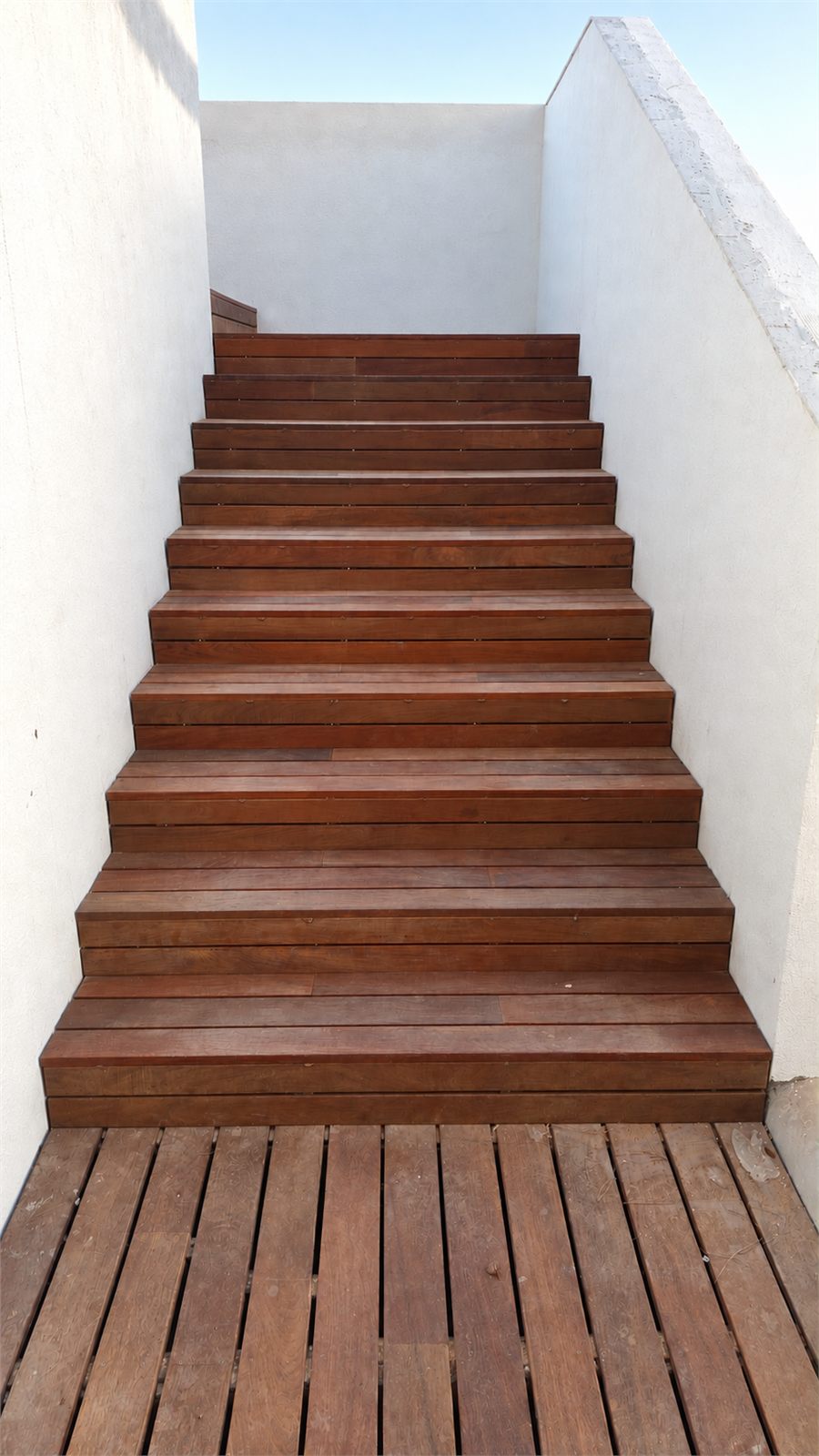 Escalera exterior revestida con tarima de madera junto a una piscina en Llíria