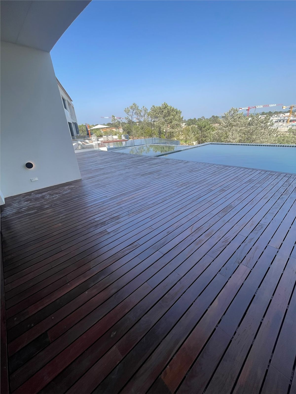 Superficie continua de tarima de madera alrededor de la piscina