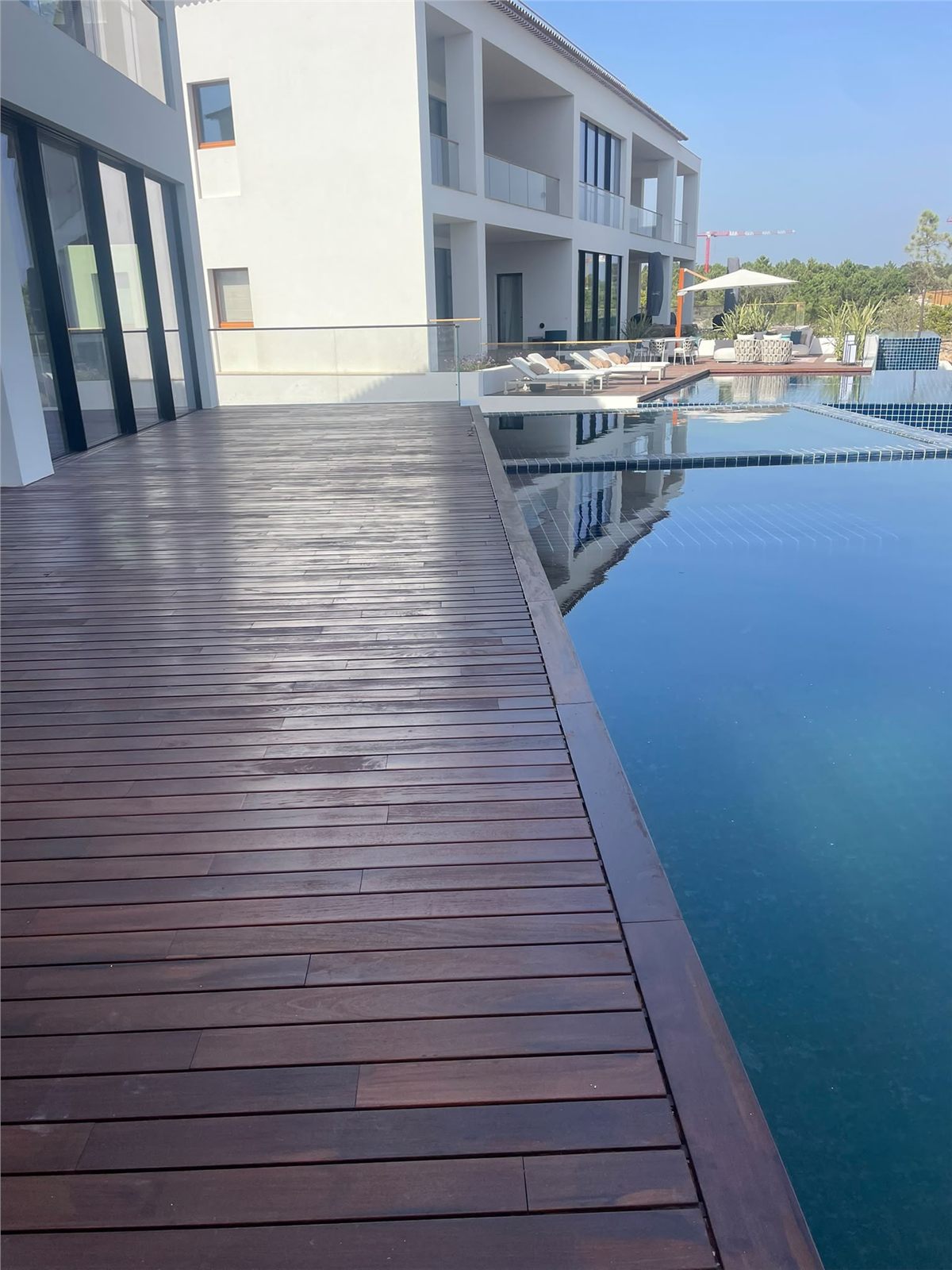 Detalle del encuentro entre la tarima exterior de madera y el borde de la piscina